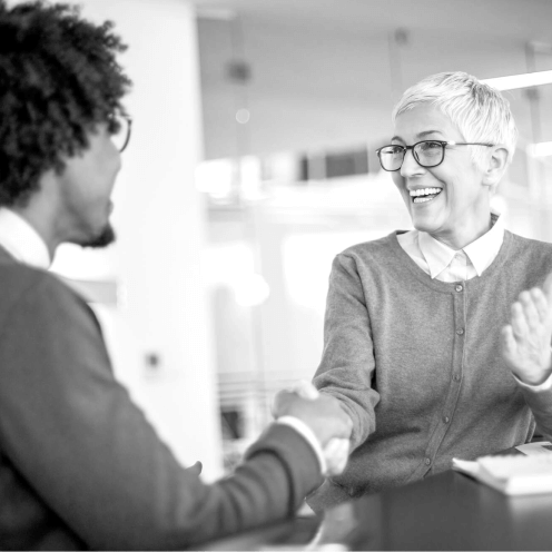 Two people shaking hands after the closing of a real estate transaction
